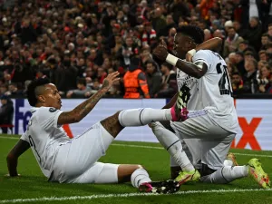 Real Madrid's Brazilian forward Vinicius Junior (R) celebrates scoring the team's second goal with Real Madrid's Brazilian forward Rodrygo (C) and Real Madrid's Brazilian defender Eder Militao during the UEFA Champions League last 16 first leg football match between Liverpool and Real Madrid at Anfield in Liverpool, north west England on February 21, 2023. (Photo by Paul ELLIS / AFP)
