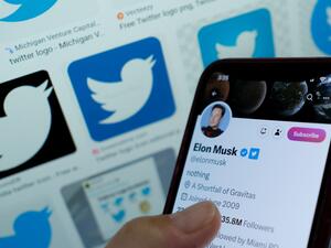 This illustration photo taken in Los Angeles on April 20, 2023, shows Elon Musk's blue tick next to his name on a smartphone. (Photo by Chris DELMAS / AFP)