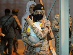 طفل ينام بين يدي مجندة سعودية في ميناء الملك فيصل