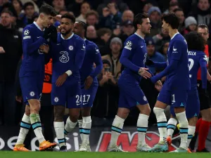 Chelsea's German midfielder Kai Havertz (L) is mobbed by teammates after scoring the team's second goal from the penalty spot during the UEFA Champions League round of 16 second-leg football match between Chelsea and Borrusia Dortmund at Stamford Bridge in London on March 7, 2023. (Photo by Adrian DENNIS / AFP)