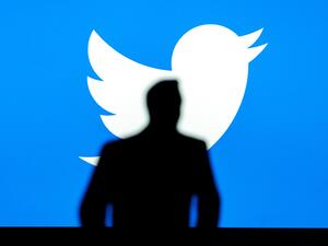 PARIS, FRANCE, OCTOBER 8. 2022: Silhouette of businessman Elon Musk, logo of Twitter in blue background. Business photo, social media.