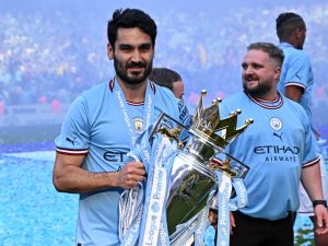 Manchester City's German midfielder Ilkay Gundogan poses with the Premier League trophy on the pitch after the presentation ceremony (Photo by Oli SCARFF / AFP)