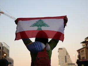 فتاة تحمل العلم اللبناني فوق رأسها