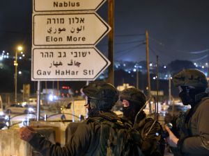 جنود اسرائيليون يقفون على تقاطع لشارع يربط بين المستوطنات في نابلس