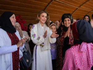 الملكة رانيا ترتدي زيا تراثيا أبيض اللون وسط مجموعة من النساء 