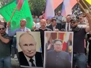 متظاهرون في الخليل يرفعون صور بوتين وكيم جونغ اون