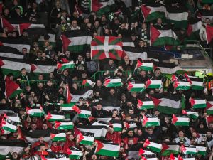 جماهير سيلتك ترفع أعلام فلسطين خلال المباراة أمام أتلتيكو مدريد (Photo by ANDY BUCHANAN / AFP)