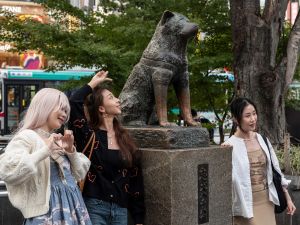(Photo by Richard A. Brooks / AFP) People posing for photos next to the statue of "Hachiko" in front of Shibuya station in central Tokyo