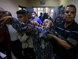 A wounded Palestinian woman trying to reach the emergency ward in south Gaza on November 13, 2023. (Mahmud Hams/ AFP)