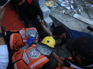 Palestinian medics work to rescue a man from the rubble of a building which collapsed following Israeli bombardment in Rafah in the southern Gaza Strip on December 1, 2023. (Said Khatib/ AFP)
