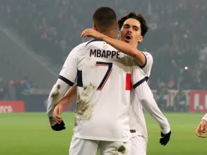 Paris Saint-Germain's French forward #07 Kylian Mbappe is congratulated by Paris Saint-Germain's Portuguese midfielder #17 Vitinha after scoring his team's first goal during the French L1 football match between Lille LOSC and Paris Saint-Germain (PSG) at Stade Pierre-Mauroy in Villeneuve-d'Ascq, northern France on December 17, 2023. (Photo by DENIS CHARLET / AFP)