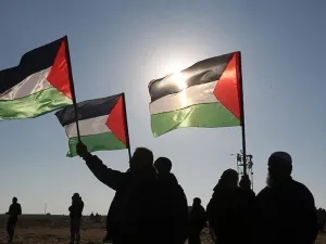 فلسطينيون يرفعون علم بلادهم