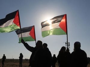 فلسطينيون يرفعون علم بلادهم