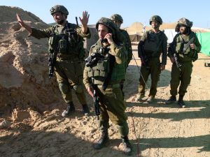  soldiers stand near the entrance of a tunnel 
