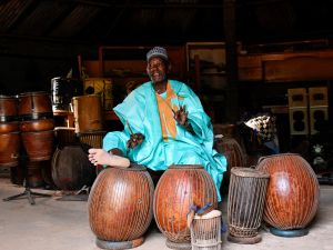 Oumarou Adamou, alias “Maïdouma”, a traditional Nigerien percussionist artist, player and manufacturer of membranophone instruments, makes music in his workshop located within the Professional Music Training Center (Photo by BOUREIMA HAMA / AFP) traditional music