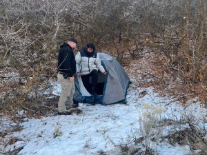 Police officer standing next with Kai Zhuang at the site where he was found in the mountains near Brigham City, Utah. (Photo by Riverdale Police Department / AFP) cyber kidnapping