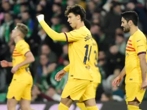 Barcelona's Portuguese forward #14 Joao Felix (C) celebrates scoring his team's third goal during the Spanish League football match between Real Betis and FC Barcelona at the Benito Villamarin stadium in Seville on January 21, 2024. (Photo by CRISTINA QUICLER / AFP)