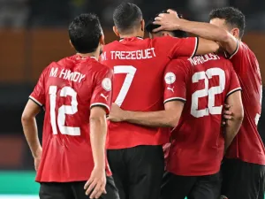 Egypt's forward #22 Omar Marmoush celebrates with teammates after scoring his team's first goal during the Africa Cup of Nations (CAN) 2024 group B football match between Egypt and Ghana at the Felix Houphouet-Boigny Stadium in Abidjan on January 18, 2024. (Photo by Issouf SANOGO / AFP)