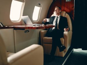 Senior businessman in suit flying in private jet