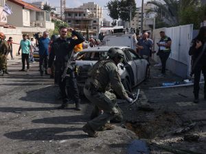 Israeli security and emergnecy personnel deploy at the site where a rocket launched from Gaza fell, in the southern city of Ashkelon on November 14, 2023, amid ongoing battles between Israel and the Palestinian Hamas movement.