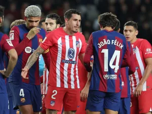 Atletico Madrid's Uruguayan defender #02 Jose Gimenez talks with Barcelona's Portuguese forward #14 Joao Felix during the Spanish league football match between FC Barcelona and Club Atletico de Madrid at the Estadi Olimpic Lluis Companys in Barcelona on December 3, 2023. (Photo by LLUIS GENE / AFP)