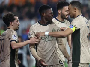Paris Saint-Germain's Portuguese defender #02 Nuno Mendes (C) celebrates with Paris Saint-Germain's French forward #07 Kylian Mbappe (R) and Paris Saint-Germain's Portuguese midfielder #17 Vitinha (L) after scoring his team's sixth goal during the French L1 football match between Montpellier Herault SC and Paris-Saint-Germain (PSG) at Stade de la Mosson in Montpellier, southern France, on March 17, 2024. (Photo by Pascal GUYOT / AFP)