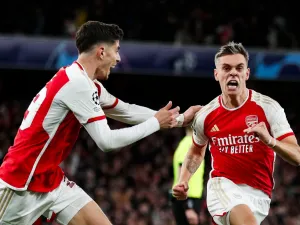 Arsenal's Belgian midfielder #19 Leandro Trossard (R) celebrates after scoring his team second goal during the UEFA Champions League quarter final first-leg football match between Arsenal and Bayern Munich at the Arsenal Stadium, in north London, on April 9, 2024. (Photo by Ian Kington / IKIMAGES / AFP)