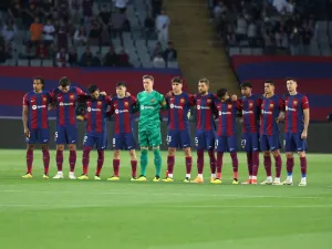 Players observe a minute of silence in tribute to late Argentinian coach Cesar Luis Menotti prior the Spanish league football match between FC Barcelona and Real Sociedad at the Estadi Olimpic Lluis Companys in Barcelona on May 13, 2024. (Photo by LLUIS GENE / AFP)