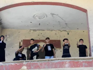 أطفال لبنانيون يرفعون شارة النصر من داخل منزلهم المدمر في جنوب لبنان