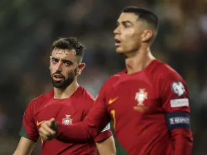 Portugal's midfielder #08 Bruno Fernandes (L) speaks with Portugal's forward #07 Cristiano Ronaldo during the UEFA Euro 2024 group J qualifying football match between Portugal and Iceland at the Jose Alvalade stadium in Lisbon on November 19, 2023. (Photo by PATRICIA DE MELO MOREIRA / AFP)