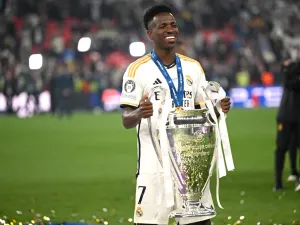 Real Madrid's Brazilian forward #07 Vinicius Junior poses with the trophy to celebrate the victory at the end of the UEFA Champions League final football match between Borussia Dortmund and Real Madrid, at Wembley stadium, in London, on June 1, 2024. (Photo by INA FASSBENDER / AFP)
