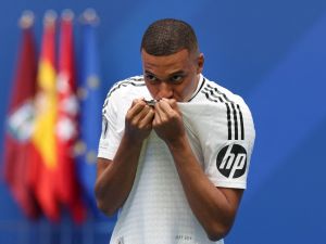 مبابي يقبل قميص ريال مدريد (Photo by Pierre-Philippe MARCOU / AFP)
