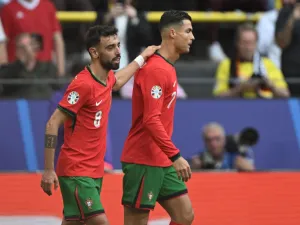 Portugal's midfielder #08 Bruno Fernandes celebrates with Portugal's forward #07 Cristiano Ronaldo (R) after scoring his team's third goal during the UEFA Euro 2024 Group F football match between Turkey and Portugal at the BVB Stadion in Dortmund on June 22, 2024. (Photo by PATRICIA DE MELO MOREIRA / AFP)