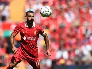 Liverpool's Egyptian striker #11 Mohamed Salah focuses on the ball during the pre-season friendly football match between Liverpool and Sevilla at Anfield stadium in Liverpool, northwest England on August 11, 2024. (Photo by Peter POWELL / AFP)