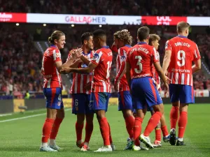 Atletico Madrid's English midfielder #04 Conor Gallagher celebrates with teammates scoring his team's first goal during the Spanish league football match between Club Atletico de Madrid and Valencia CF at the Metropolitano stadium in Madrid on September 15, 2024. (Photo by Pierre-Philippe MARCOU / AFP)