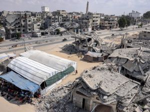 Muslim worshippers perform the weekly Friday prayers in a tent enclosure by destroyed buildings in Khan Yunis in the southern Gaza Strip on October 18, 2024 amid the ongoing war in the Palestinian territory between Israel and Hamas. (Photo by BASHAR TALEB / AFP)
