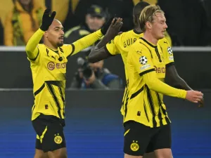 Dortmund's Dutch forward #21 Donyell Malen celebrates scoring the opening goal with his teammates Dortmund's Guinean forward #09 Serhou Guirassy and Dortmund's German midfielder #10 Julian Brandt during the UEFA Champions League football match BVB Borussia Dortmund vs SK Sturm Graz in Dortmund, western Germany on November 5, 2024. (Photo by INA FASSBENDER / AFP)