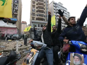 لبنانيون يرفعون رايات حزب الله بين ركام المباني المدمرة في الضاحية الجنوبية 