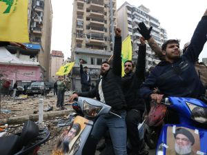 لبنانيون يرفعون رايات حزب الله بين ركام المباني المدمرة في الضاحية الجنوبية 