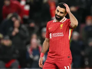 Liverpool's Egyptian striker #11 Mohamed Salah reacts after failing to score from the penalty spot during the UEFA Champions League football match between Liverpool and Real Madrid at Anfield in Liverpool, north west England on November 27, 2024. (Photo by Oli SCARFF / AFP)