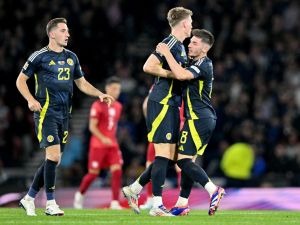Scotland's midfielder #08 Billy Gilmour (R) celebrates with Scotland's midfielder #04 Scott McTominay (C) and Scotland's midfielder #23 Kenny McLean scoring the team's first goal during the UEFA Nations League League A Group 1 football match between Scotland and Poland, at Hampden Park stadium, in Glasgow, on September 5, 2024. (Photo by ANDY BUCHANAN / AFP)