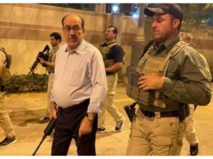 المالكي حاملا السلاح في أحد شوارع بغداد