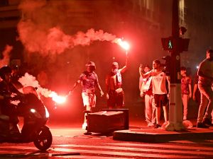 Paris Saint-Germain (PSG) supporters gather holding flares on a street in Paris early June 1, 2025, during celebrations following their 5-0 victory in the UEFA Champions League final football match between Paris Saint-Germain (PSG) and Inter Milan held in Munich. (Photo by LOU BENOIST / AFP)