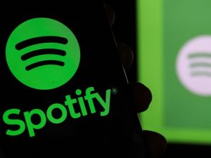 Bandung, Indonesia - January 4, 2025: In this photo illustration, Spotify logo is displayed on a smartphone with Spotify Musik Logo in the background. (Shutterstock) Spotify