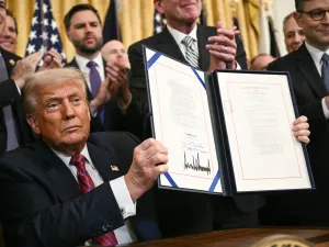 US President Donald Trump displays the GENIUS Act 