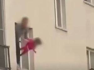 رجل يعلق ابنته البالغة من العمر ثلاث سنوات من النافذة كرهينة، ويُهددها بسكين 