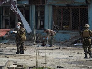 An Afghan investigator (C) inspect the remains of a body at the site where a suicide attacker blew himself up in a Shiite area of Kabul on Mar. 9, 2018. A suicide bomber on foot blew himself up in Kabul's Shiite area on Mar. 9, killing at least seven people, officials said, as militants dial up pressure on the war-weary Afghan capital.
(SHAH MARAI / AFP)