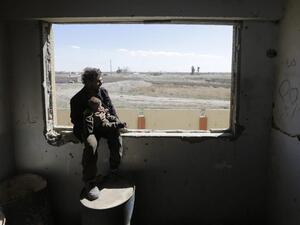 A Syrian man carries a child, after being evacuated from rebel-held areas in the Eastern Ghouta, at a school in the regime-controlled Hosh Nasri, on the northeastern outskirts of the capital Damascus on Mar.16, 2018, ahead of being relocated to other areas. (LOUAI BESHARA / AFP)