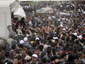 Palestinians gather to receive lunch packages after Friday prayers during a tent city protest near the border with Israel east of Gaza City to commemorate Land Day on Mar. 30, 2018. Land Day marks the killing of six Arab Israelis during 1976 demonstrations against Israeli confiscations of Arab land.
(MAHMUD HAMS / AFP)