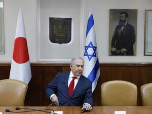 Israeli Prime Minister Benjamin Netanyahu sits in conference room before flags of Japan (L), Israel (C), and a portrait of Theodor Herzl (seen as "Visionary of the Jewish State" and founder of modern Zionism) at the PM office ahead of his meeting with his Japanese counterpart in Jerusalem on May 2, 2018. 
(Abir SULTAN / POOL / AFP)